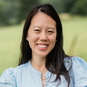 Doctor Nancy Ha, smiling, outdoors on a summer afternoon.